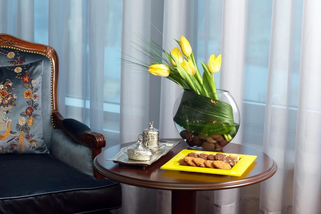 Orion Hotel 비슈케크 외부 사진 A table with a vase of flowers
